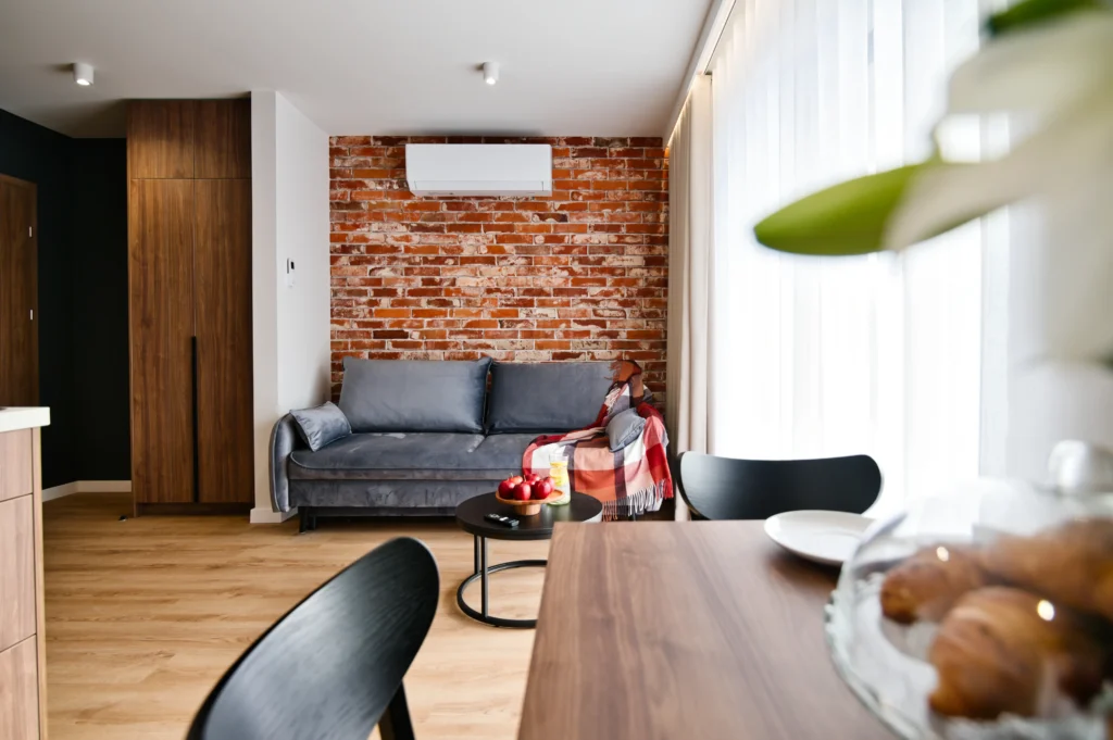 apartament w Zatorze – salon z sofą i stołem jadalnym dla 5 osób