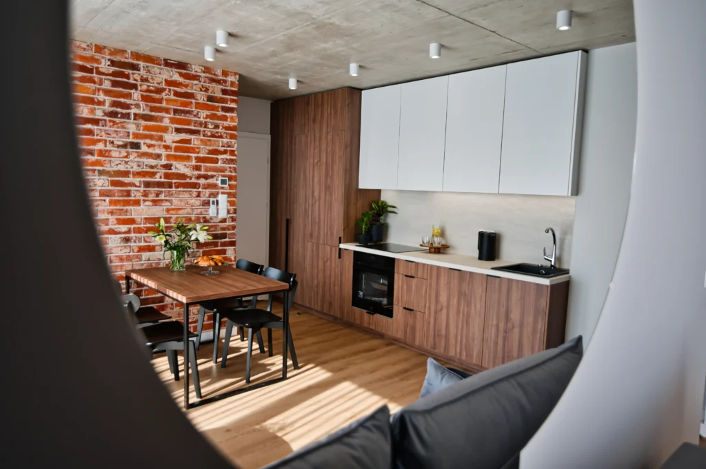 apartament w Zatorze – kuchnia i salon z kanapą i stołem dla 4 osób