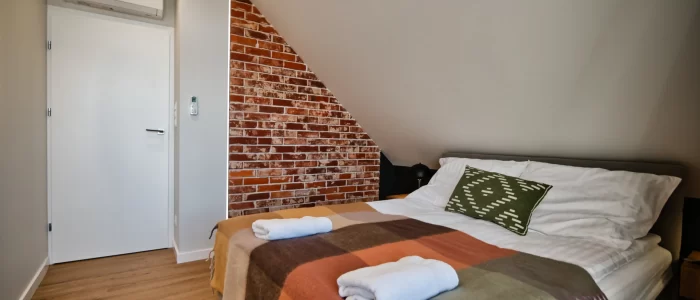 Apartment for 11 - main bedroom - king sized bed and a brick wall